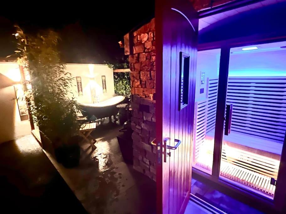 ein Badezimmer mit einem Waschbecken und ein Fenster mit violetten Lichtern in der Unterkunft The Bath House & Sauna Garden x 4 beds in Newcastle