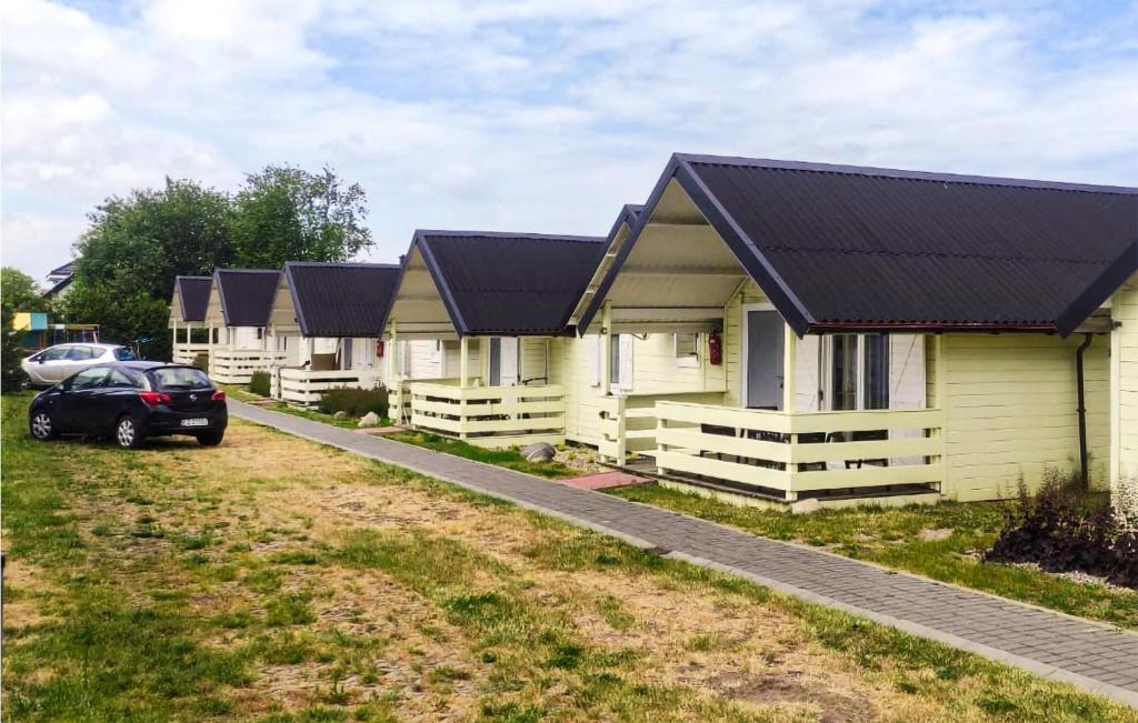 a row of yellow houses with black roofs at Stunning Home In Ustronie Morskie in Ustronie Morskie