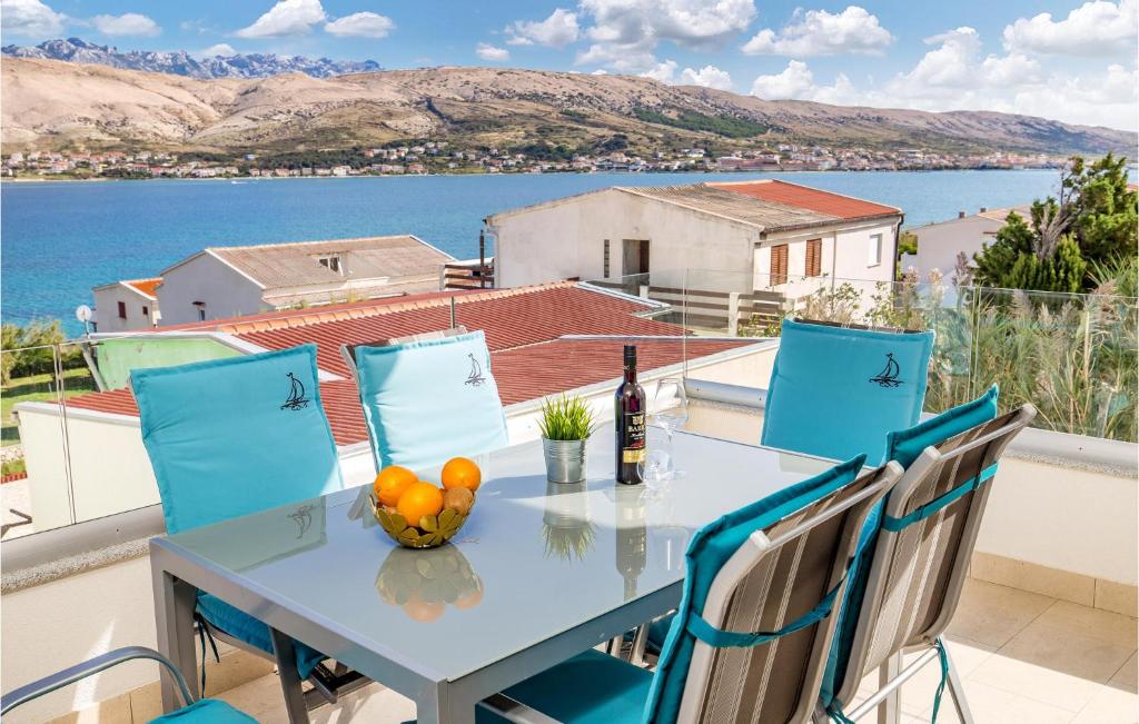 a table and chairs on a balcony with a view of the water at Amazing Apartment In Pag With Wifi in Pag