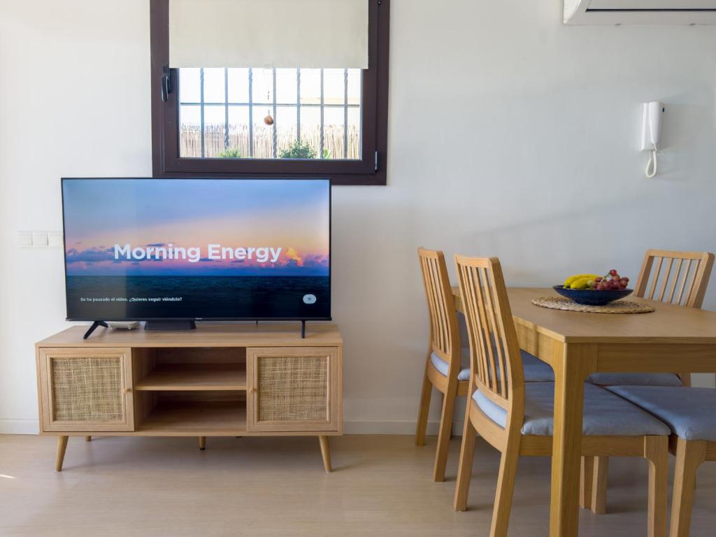 Una sala de estar con un televisor sobre una mesa de madera. en Apartamento en la playa, en Castelldefels