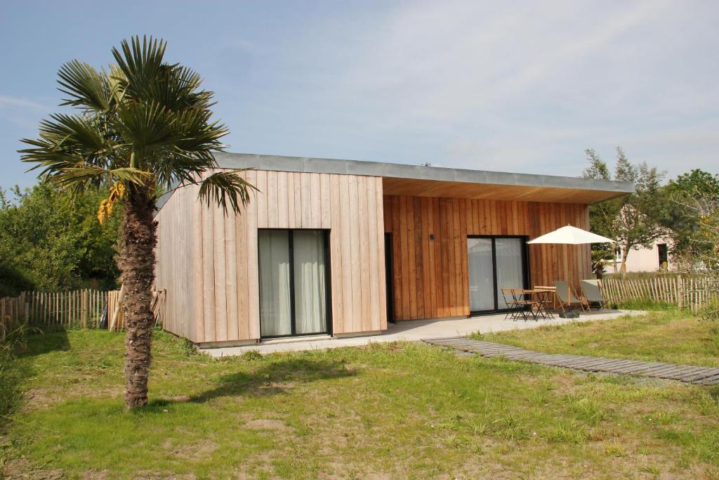 dom z palmą przed nim w obiekcie Casa Cotentins w mieście Gouville-sur-Mer