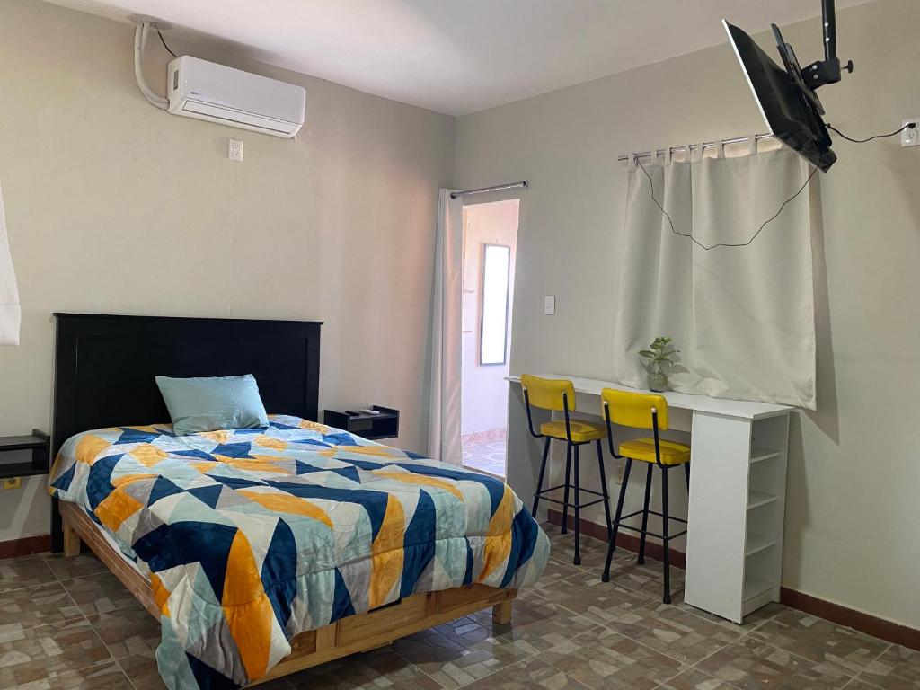 una camera da letto con un letto, una scrivania e delle sedie di Departamento Céntrico a San Luis Potosí