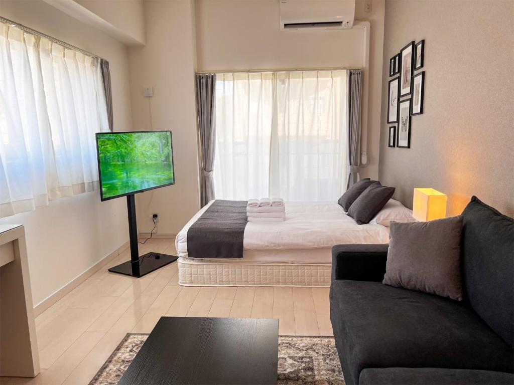 ein Wohnzimmer mit einem Bett und einem Flachbildfernseher in der Unterkunft Lion Heiwa Odori - Vacation STAY 17954 in Hiroshima