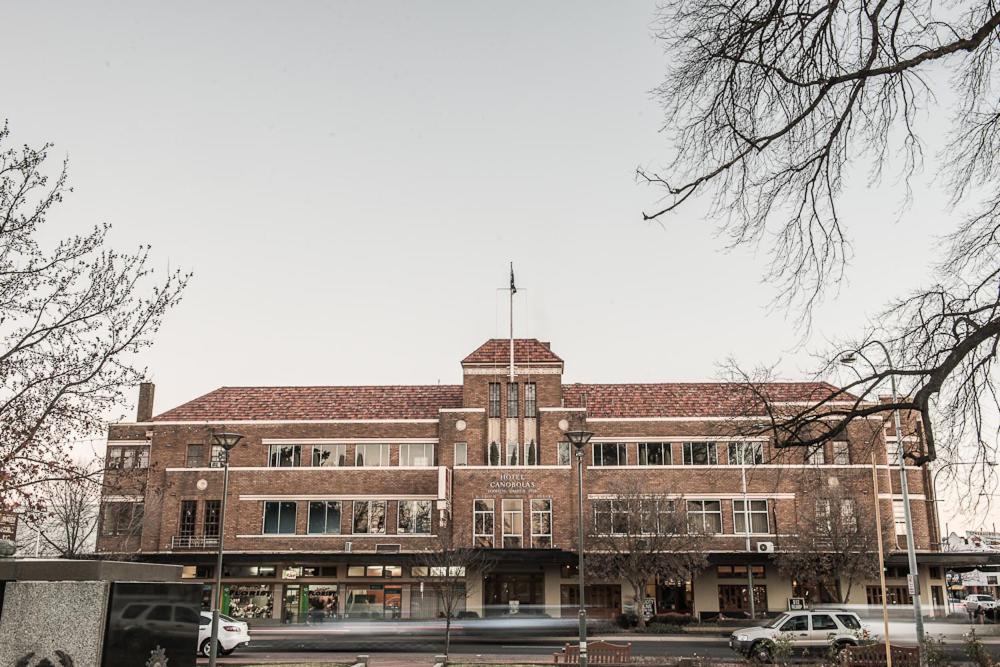 a large brick building with cars parked in front of it at Hotel Canobolas in Orange