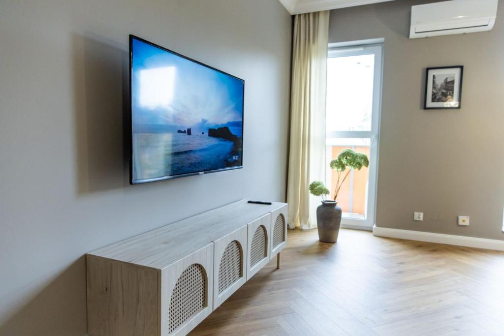 トルンにあるSOLAR Apartments I Stare Miasto 10min I Priv Parking Free I Winda I Balkonのリビングルーム(壁に大画面薄型テレビ付)