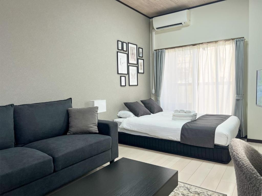 ein Wohnzimmer mit einem Bett und einer Couch in der Unterkunft Lion Heiwa Odori - Vacation STAY 17952 in Hiroshima