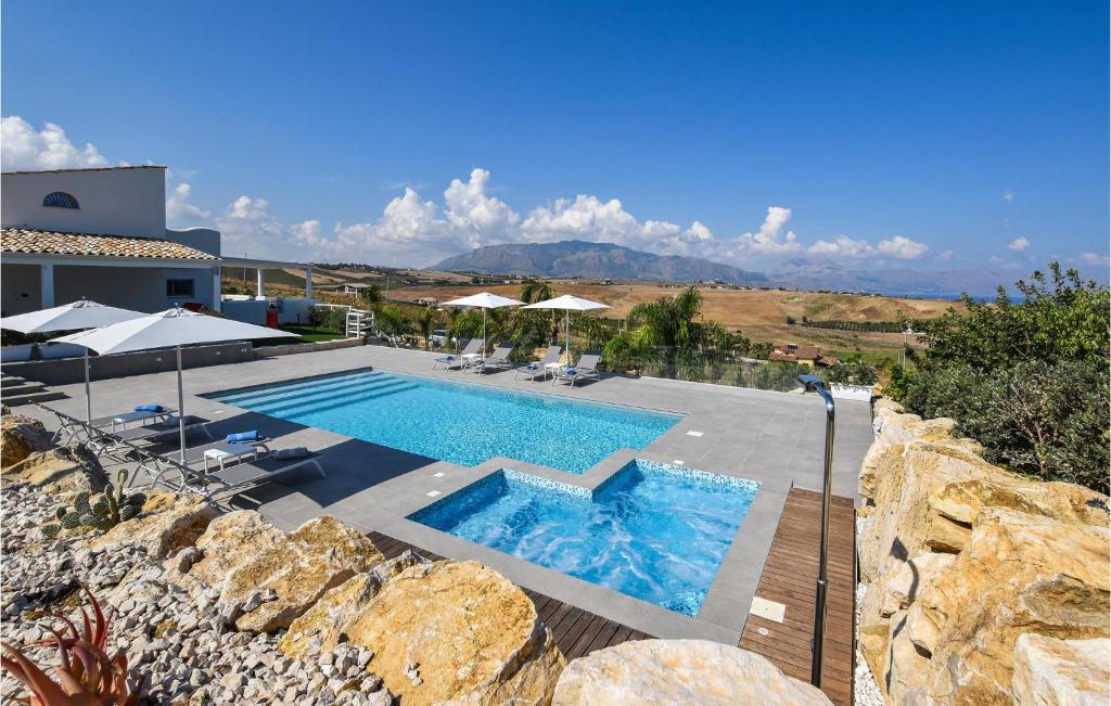 une piscine avec chaises et parasols à côté d'un bâtiment dans l'établissement Cozy Home In Partinico With Wifi, à Partinico