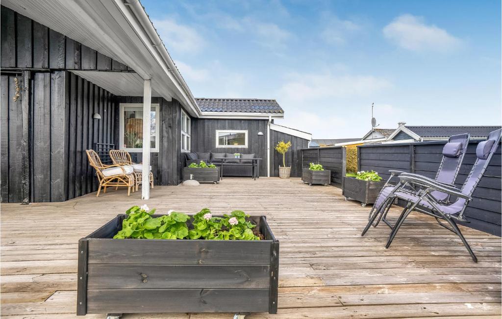a patio with a table and chairs on a wooden deck at 3 Bedroom Cozy Home In Hejls in Hejls