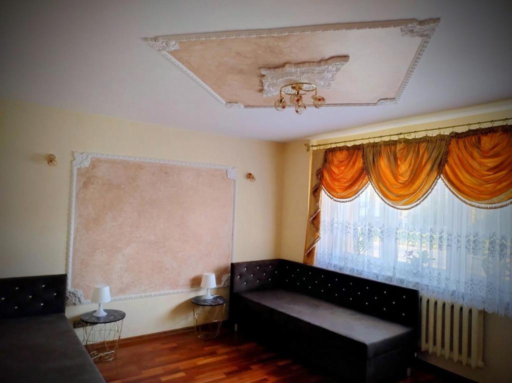 a living room with a couch and a window at Pokoje Szczecińska in Szczecin