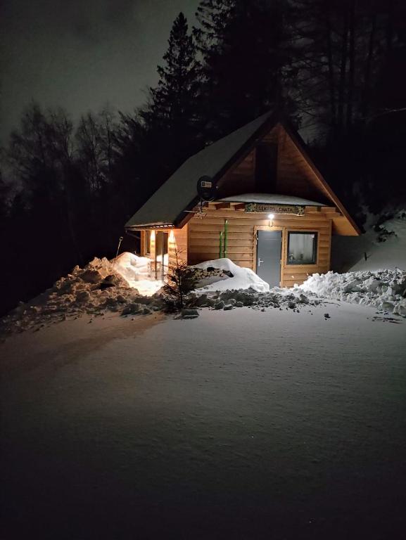 a log cabin with lights in the snow at night at Sękata Chata in Szczyrk