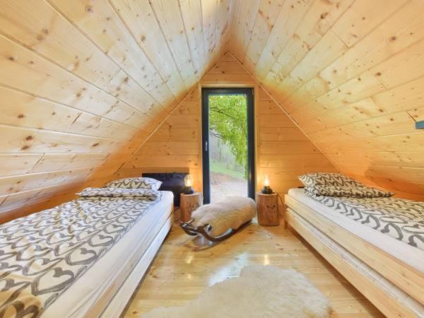 two beds in a log cabin with a window at Sękata Chata in Szczyrk