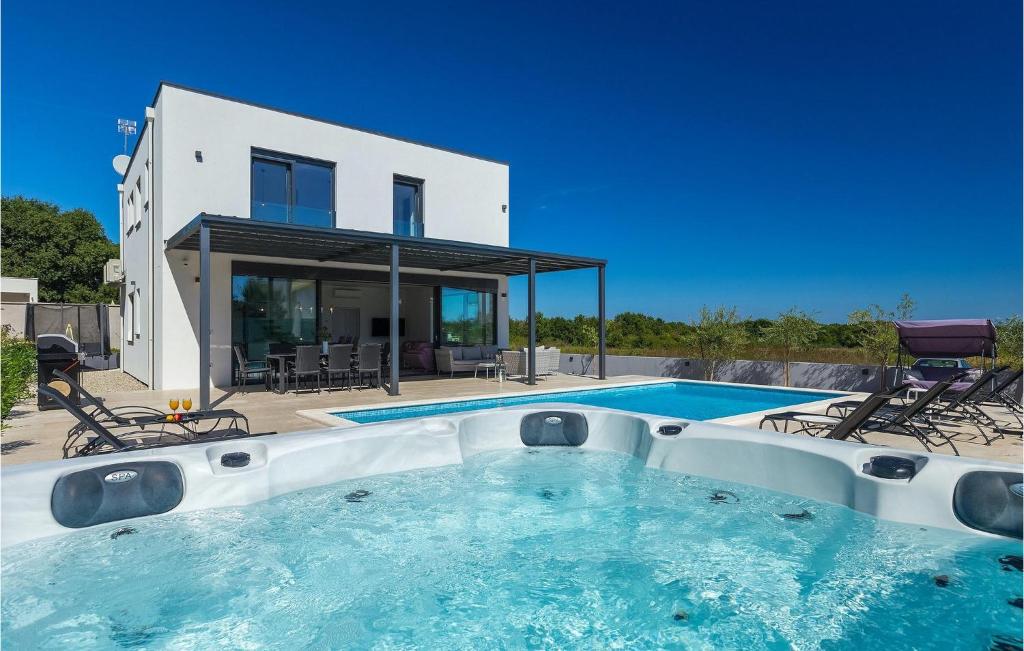 a house with a swimming pool in front of a house at Villa Sunshine Tea in Pula