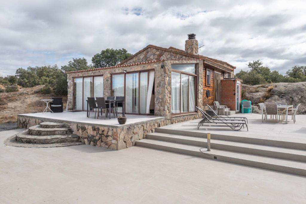 una casetta su un patio in pietra con tavolo e sedie di Finca privada 20 hectáreas con preciosa casa de campo a Navas de San Antonio