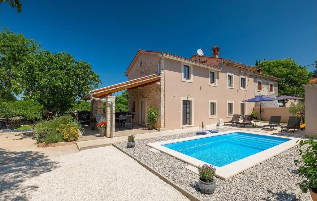 eine Villa mit einem Swimmingpool vor einem Haus in der Unterkunft Villa Ena Istra in Marčana