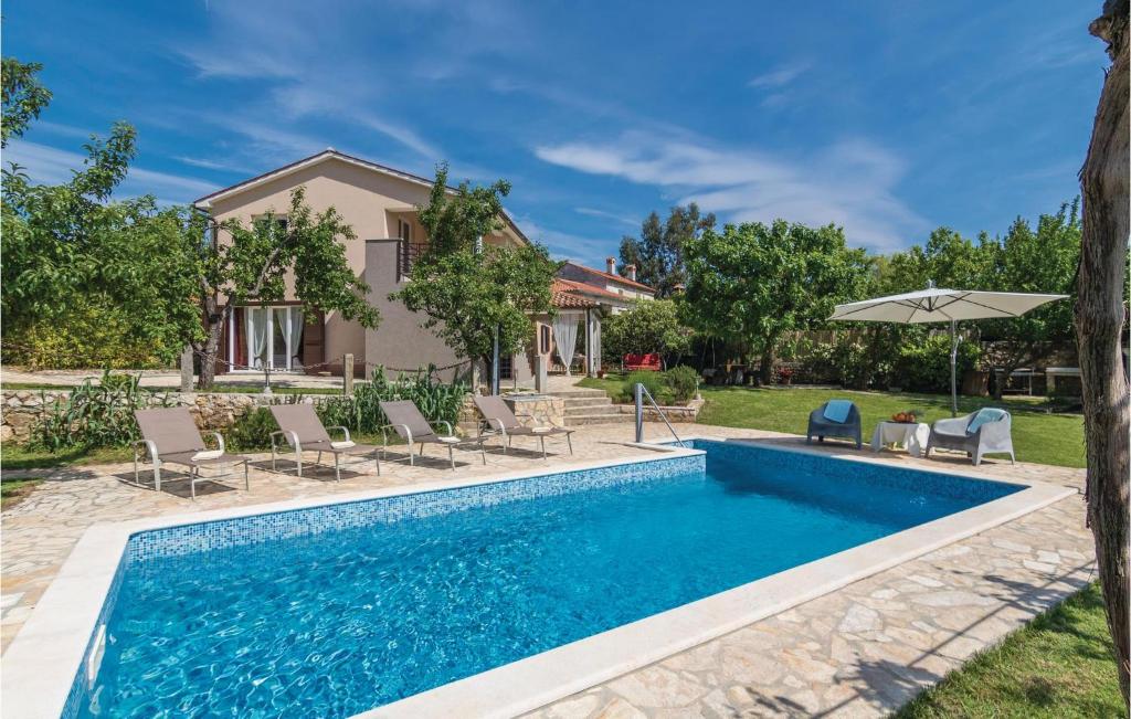 basen z krzesłami i parasolem obok domu w obiekcie Holiday Home Cere Cere Ii w mieście Santalezi