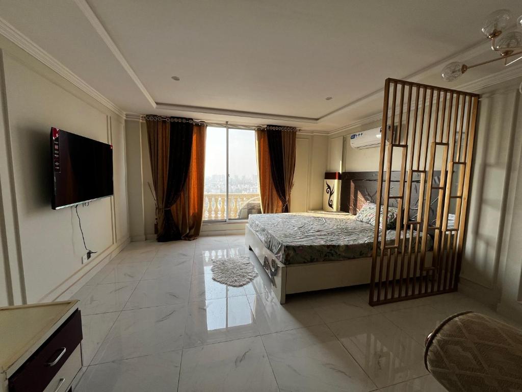 a bedroom with a bed and a large window at stunning studio apartment in Rāmkot