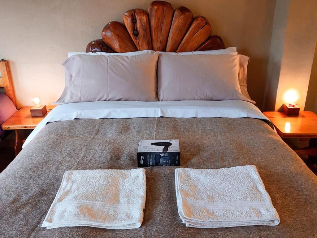 a bed with two white towels on top of it at Monoambiente Buena Vista - De Alojamientos Lago Puelo in Lago Puelo