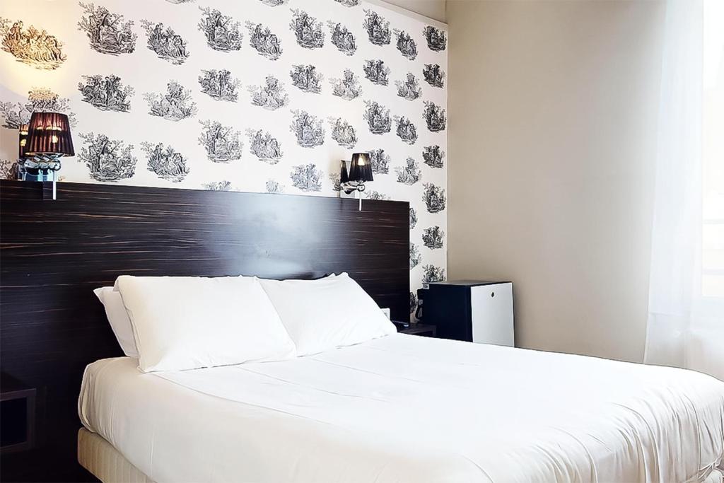 a bedroom with a white bed with a black headboard at Hôtel de Ménilmontant in Paris