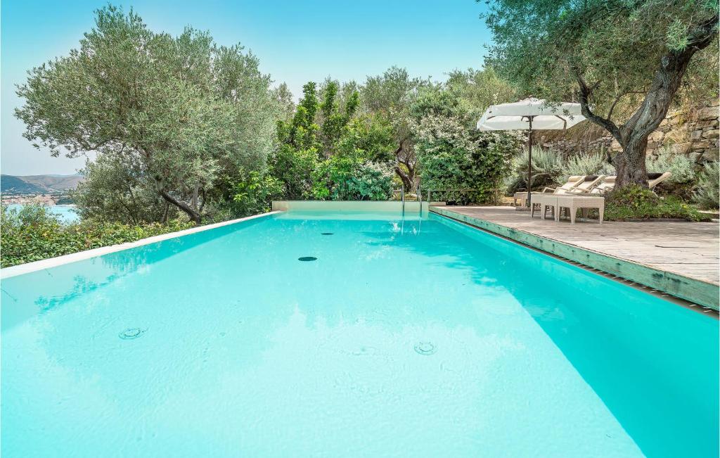 a blue swimming pool with a table and an umbrella at Rupe Alta in Castellabate