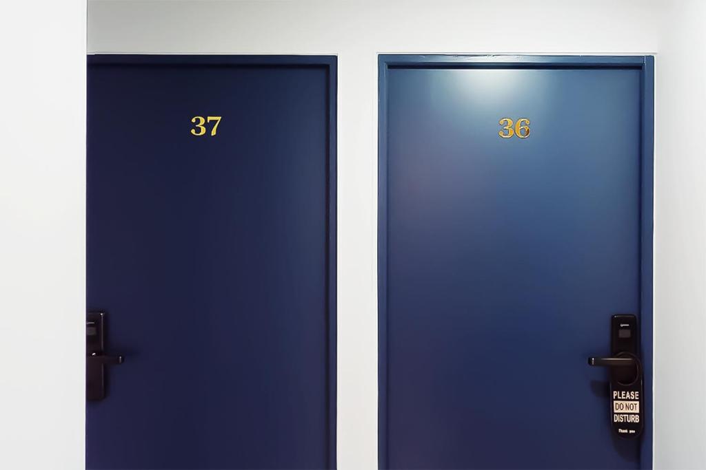 two blue doors next to each other with numbers on them at Hôtel de Ménilmontant in Paris