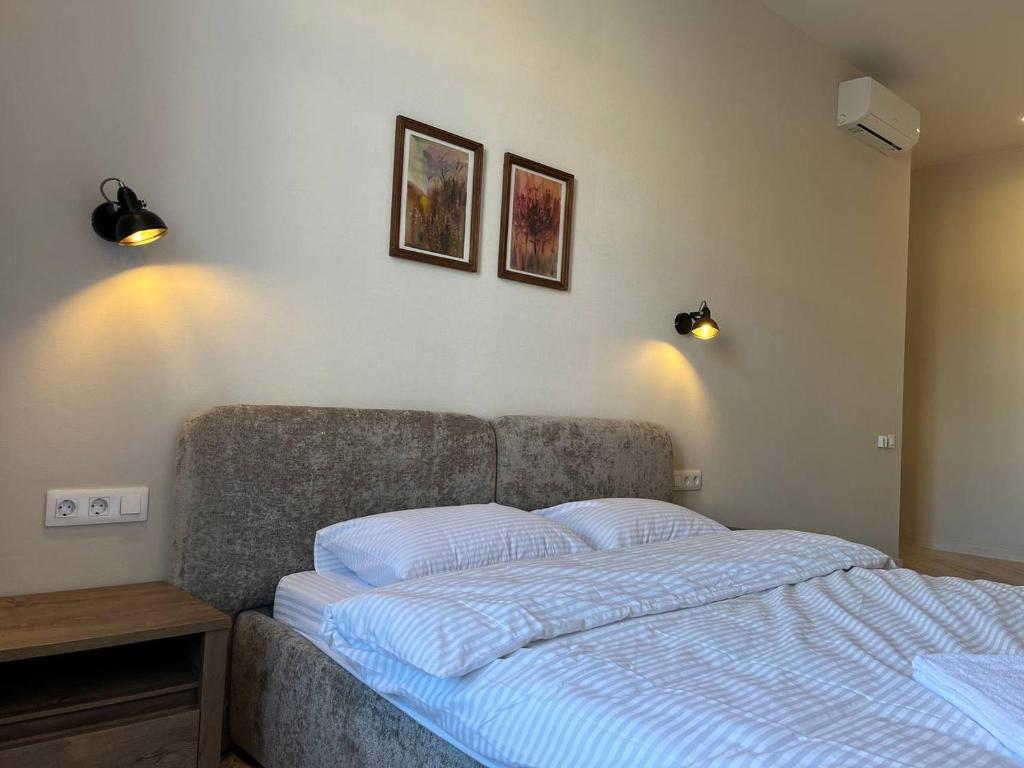 リヴィウにあるSweet Apartaments near Opera Houseの壁に2枚の写真が飾られたベッドルームのベッド1台