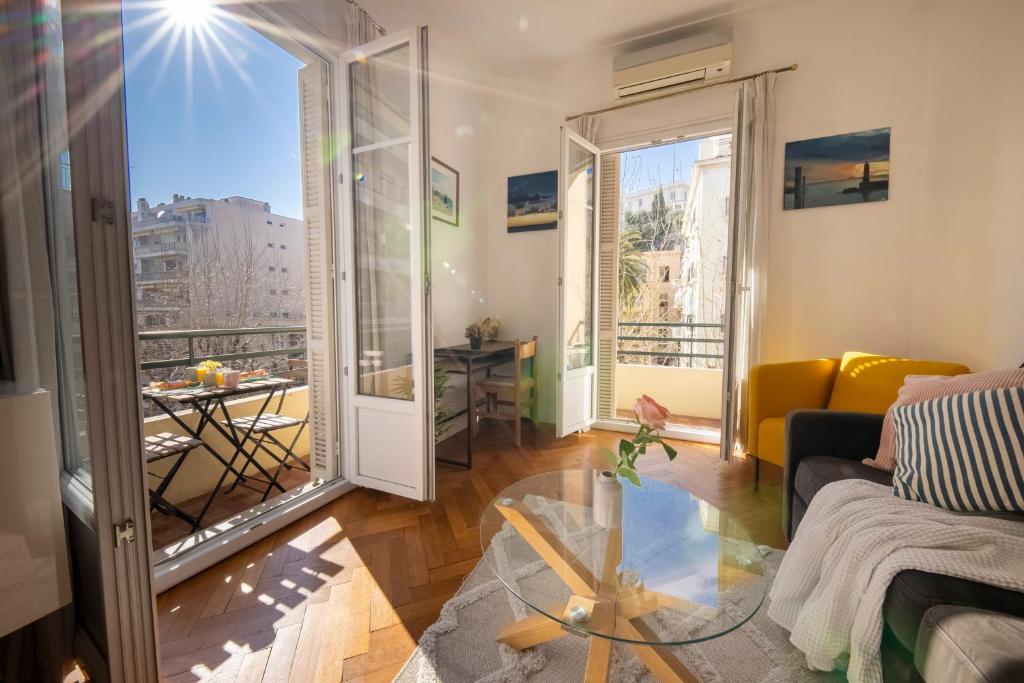 un salon avec un canapé et une table en verre dans l'établissement * Le Provençal * cosy flat 3 min walk from the sea, à Nice