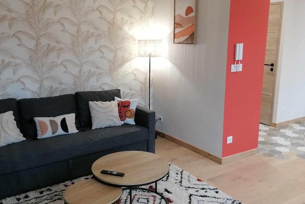 un salon avec un canapé et une table dans l'établissement Appartement neuf dans Résidence, à La Bourboule