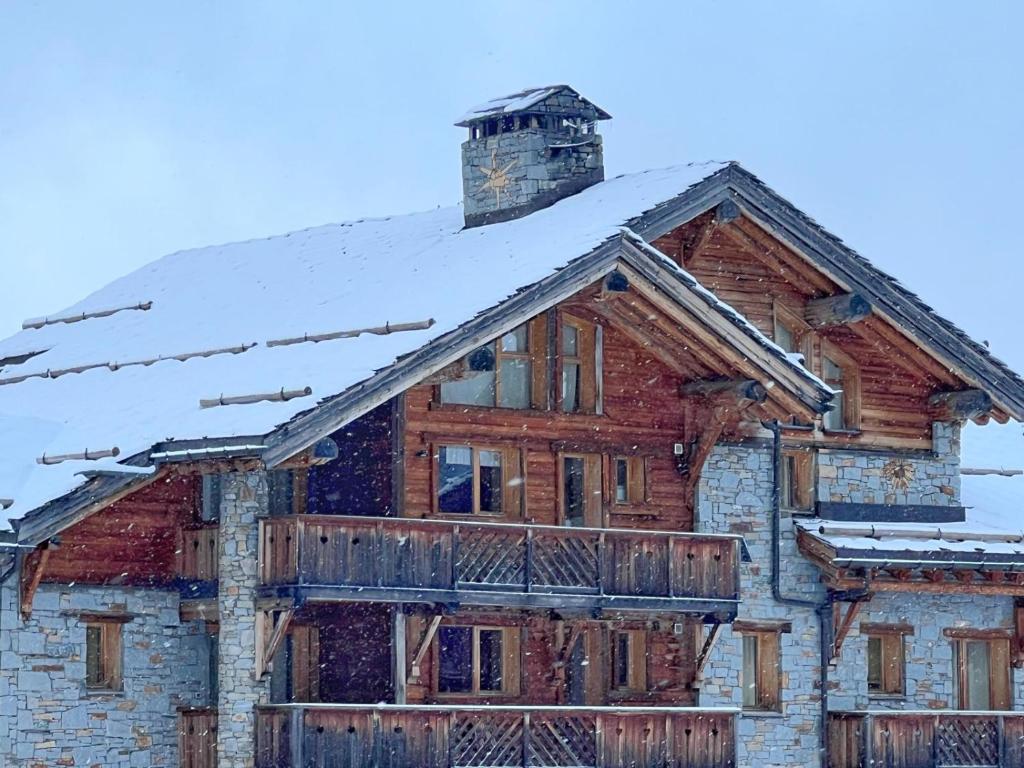 a log home with snow on the roof at Le Refuge - 5 bedroom chalet with sauna in Sainte-Foy-Tarentaise