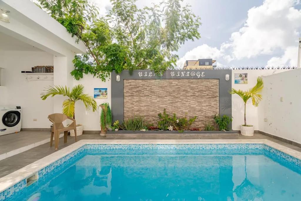 a swimming pool in front of a building at Villa Vintage. in Boca Chica