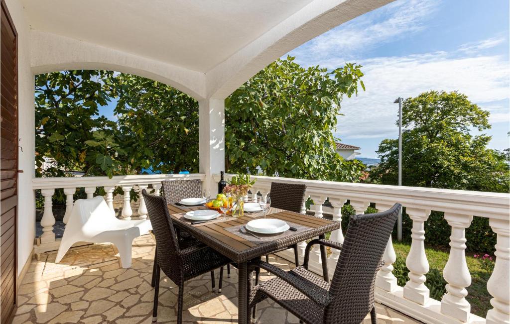 a porch with a wooden table and chairs at 1 Bedroom Amazing Apartment In Krk in Krk