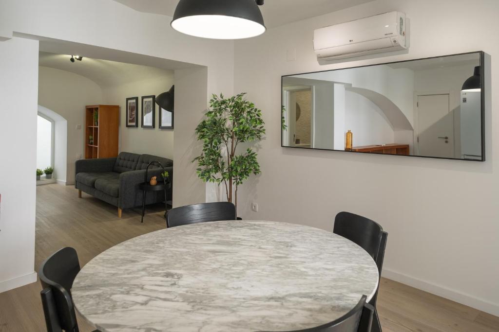 Un comedor con una mesa y sillas y un espejo. en Casa do Torres, en Évora