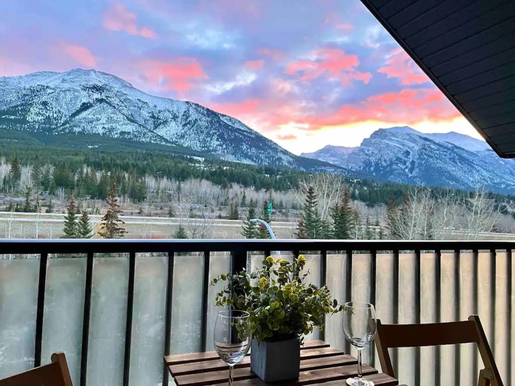a table on a balcony with a view of mountains at Stunning Silver Creek 1Br Mtn view penthouse in Canmore