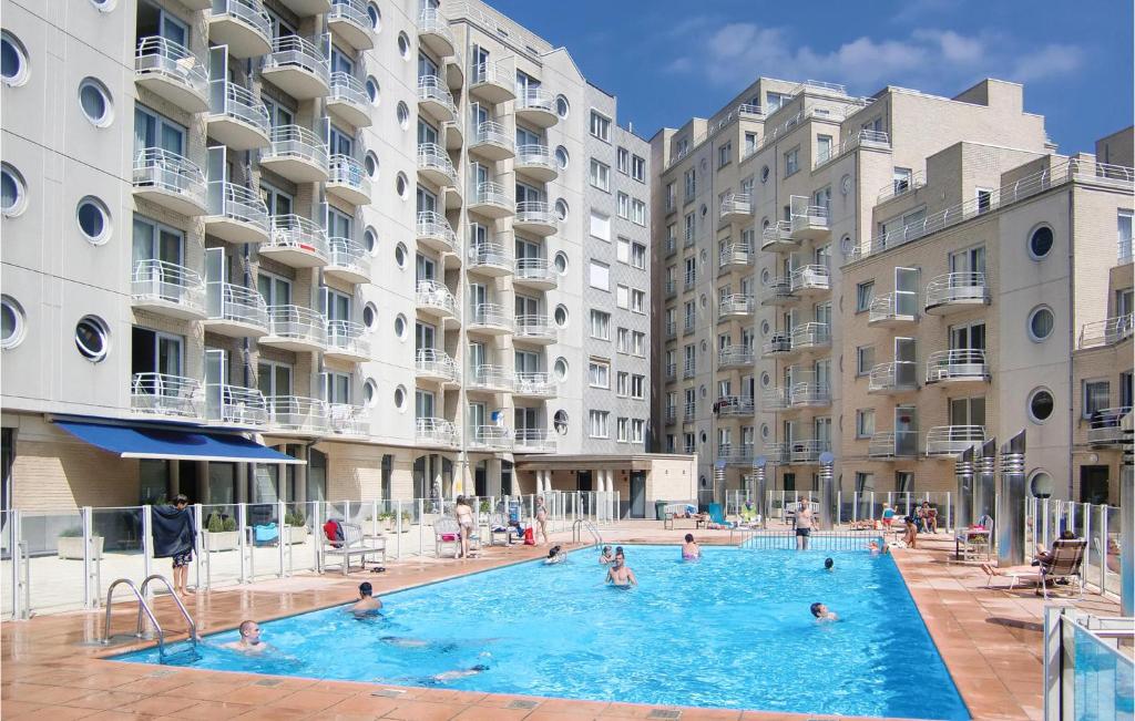 a group of people in a swimming pool in front of buildings at Residentie Zeezicht in Ostend