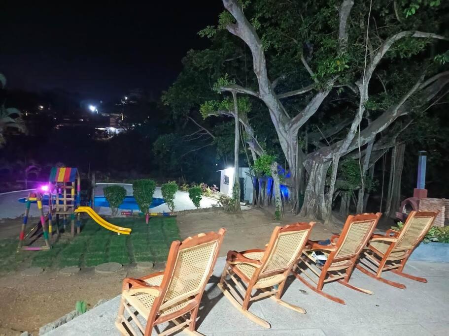 a group of chairs and a playground at night at campestre, naturaleza, confort, familiar in Turbaco