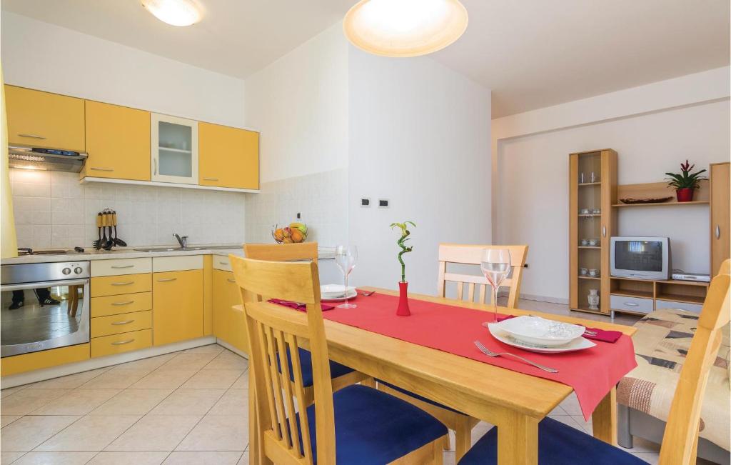 kuchnia i jadalnia ze stołem i krzesłami w obiekcie Apartment Porec 05 w Poreču