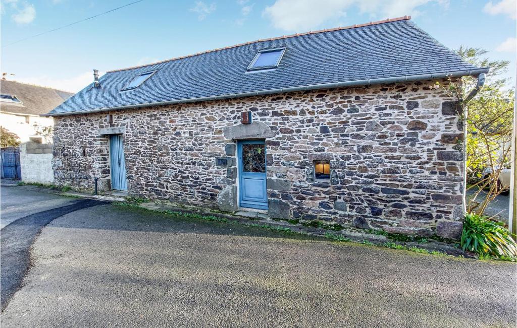 a stone house with a blue door on a street at 1 Bedroom Cozy Home In Plouézec in Plouézec