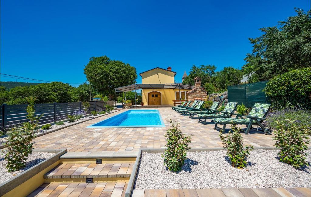 a backyard with a pool and chairs and a house at Lovely Home In Susnjevica With Kitchen in Šušnjevica
