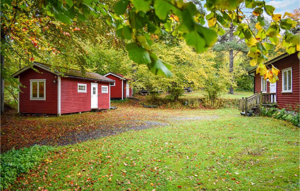 a row of small red buildings in a yard at Nice Home In Tormestorp With Lake View in Tormestorp