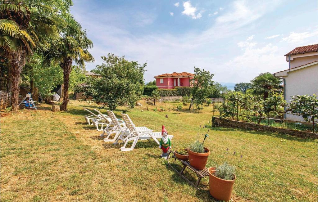 une rangée de chaises blanches assises dans une cour dans l'établissement 3 Bedroom Stunning Apartment In Lovran, à Lovran