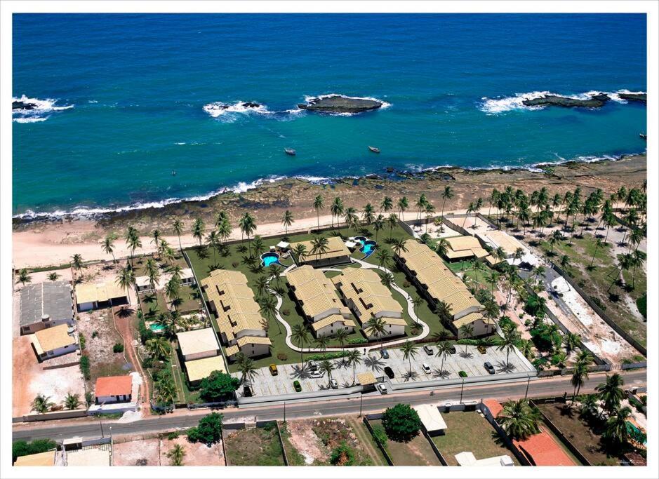 an aerial view of a resort next to the ocean at Duplex Arembepe, beira mar, piscina i wifi in Camaçari