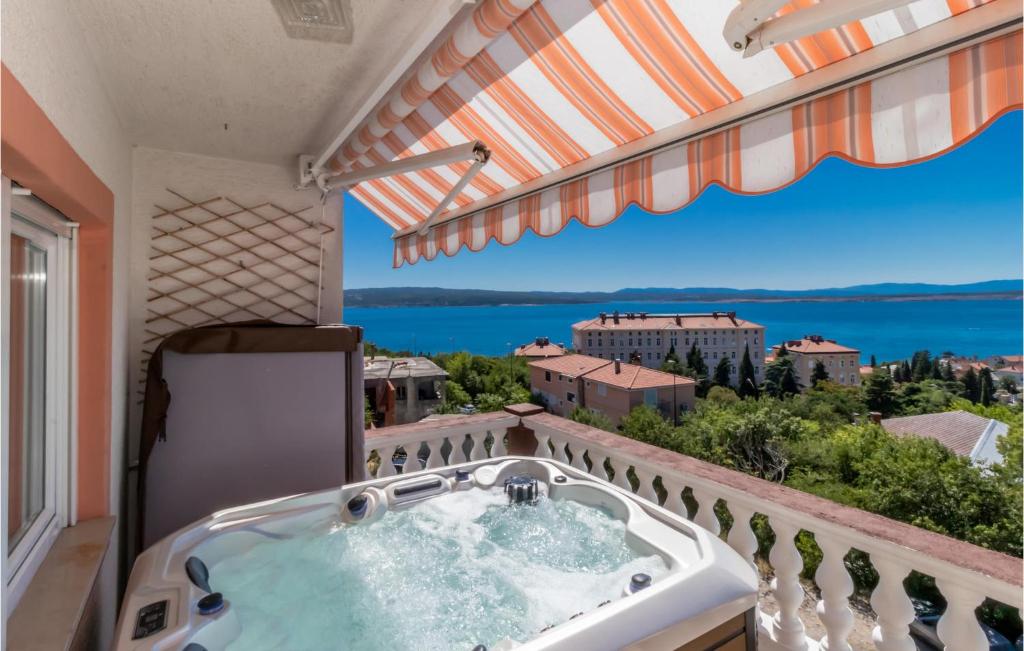 a hot tub in a balcony with a view of the water at Cozy Apartment In Crikvenica in Crikvenica