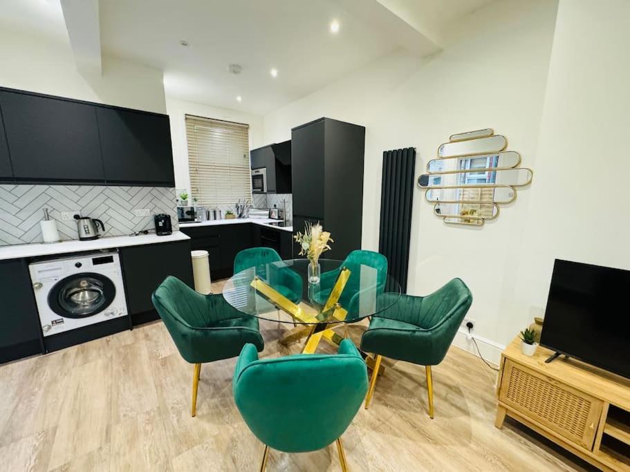 Hotel Glamorous London 2 bed stylish flat 1 min from Station, a living room with green chairs and a table at Glamorous London 2 bed stylish flat 1 min from Station in London