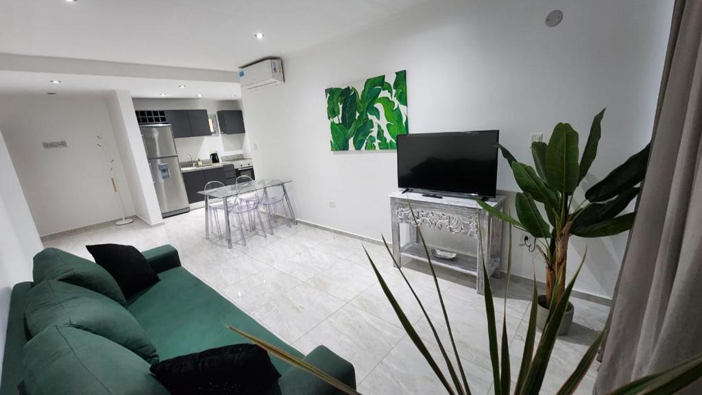 a living room with a green couch and a kitchen at Torre Charlotte in Posadas