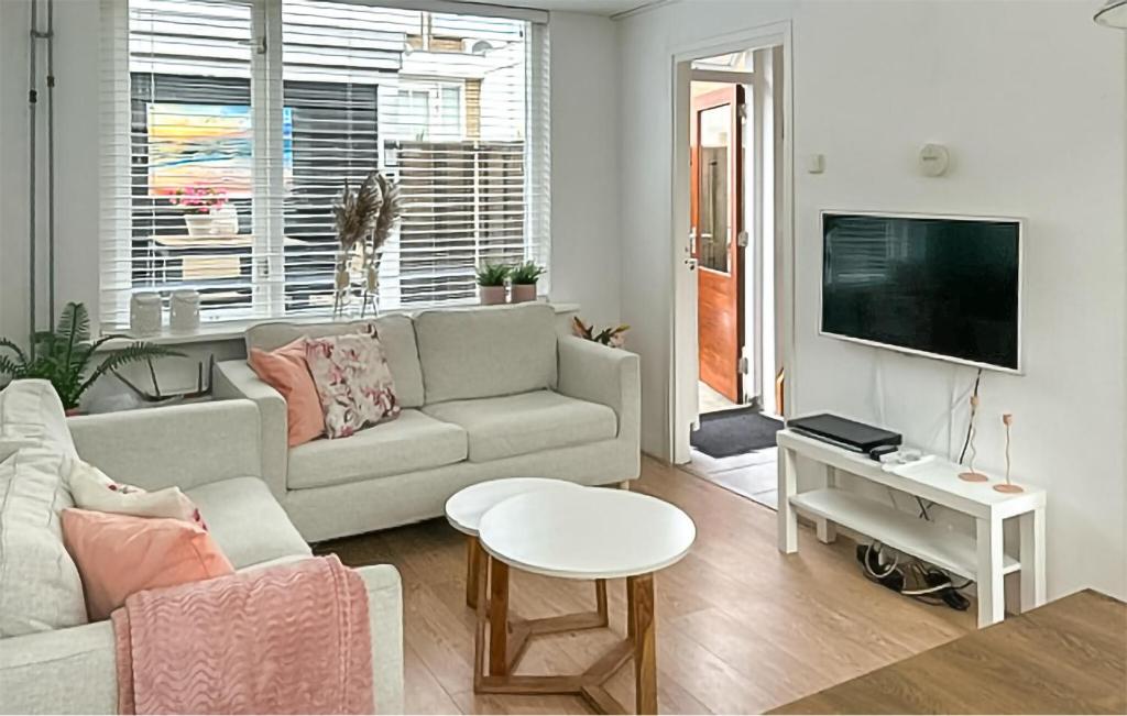 ein Wohnzimmer mit Sofa und Fernseher in der Unterkunft Dophuisje in Egmond aan Zee