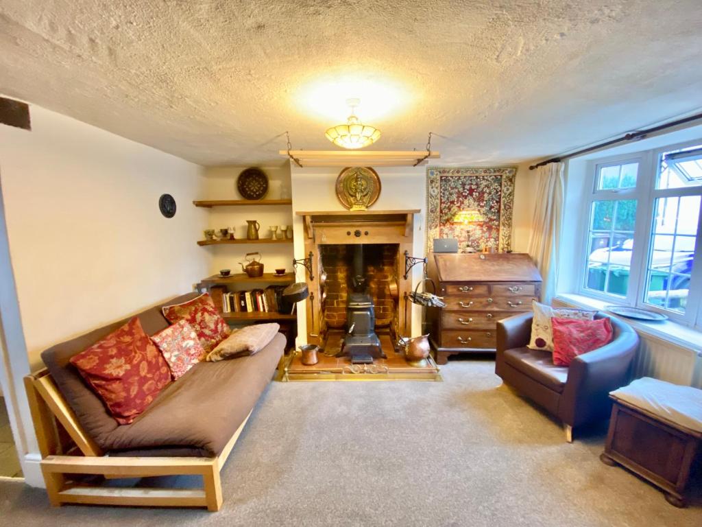 a living room with two couches and a fireplace at Bumblebee Cottage in Knowle