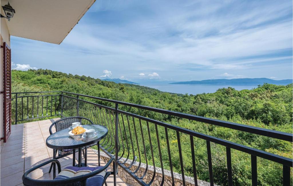 stół i krzesła na balkonie z widokiem na ocean w obiekcie 2 Bedroom Beautiful Apartment In Labin w mieście Drenje