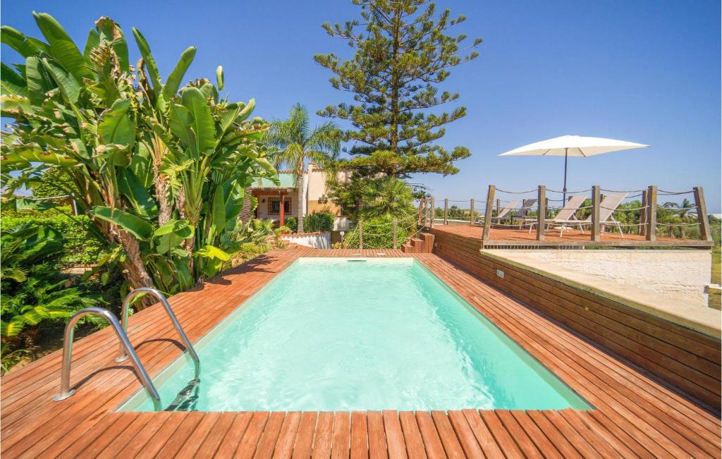 una piscina en una terraza de madera con sombrilla en Beautiful Home In Partinico Pa, en Balestrate