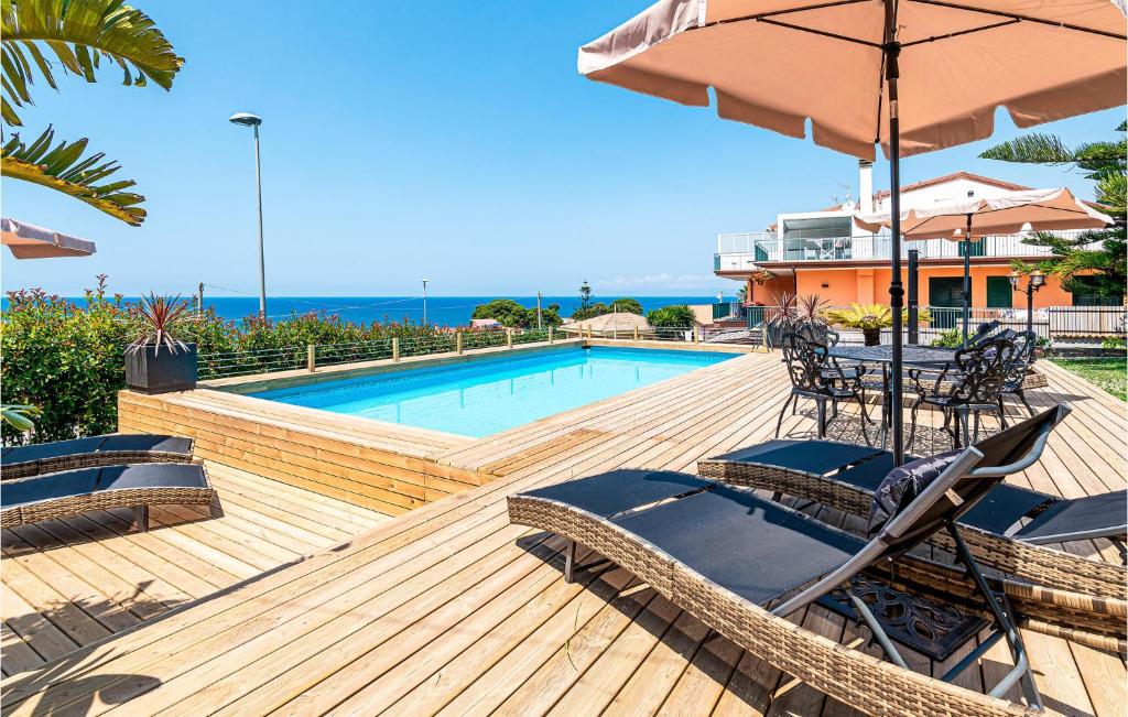 a deck with chairs and an umbrella and a pool at Amazing Apartment In Agropoli With Wifi in Agropoli