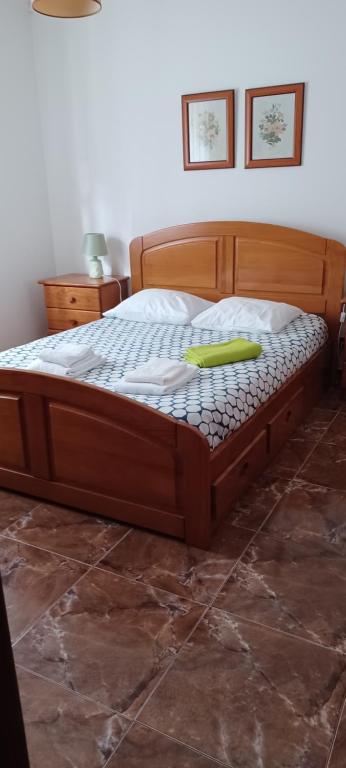 una cama de madera con un objeto verde encima en SwordFish Cliff Apartment, en Peniche