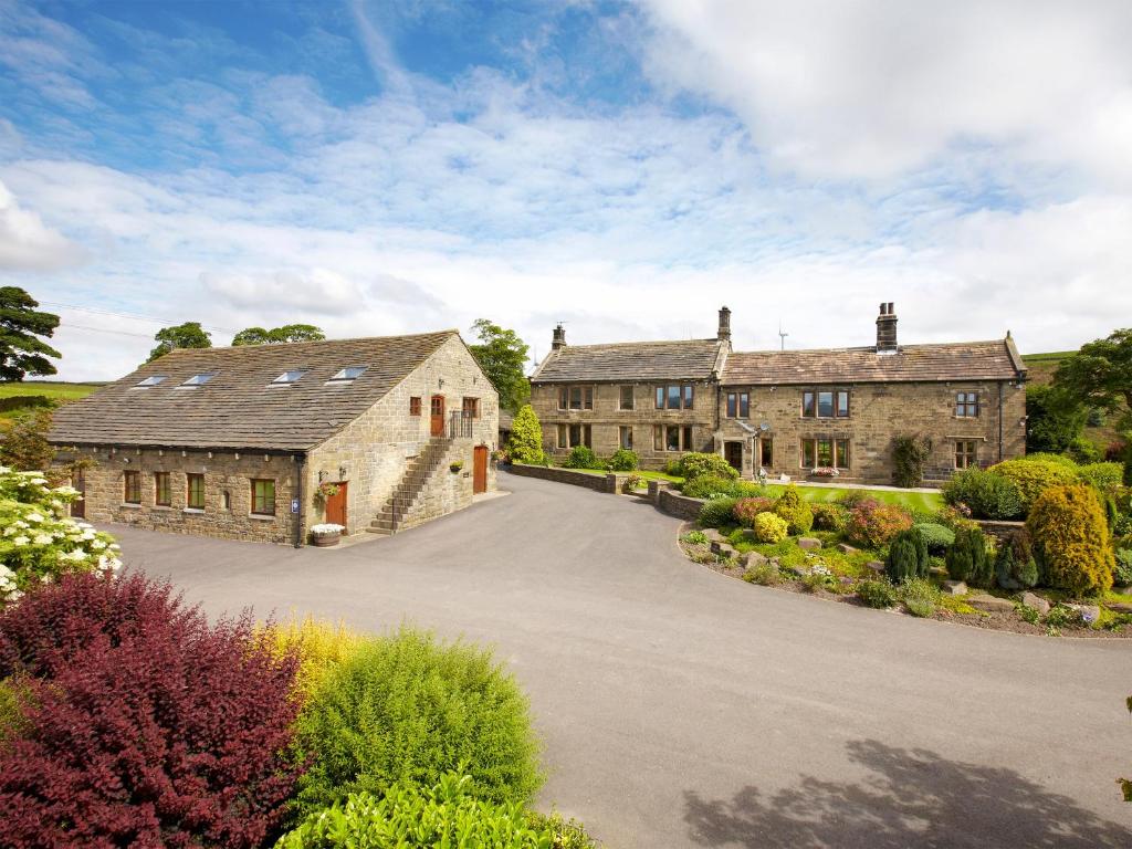 ein Grundstück mit zwei großen Steingebäuden und einer Auffahrt in der Unterkunft Rowan Cottage - Uk4187 in Hazlehead Bridge